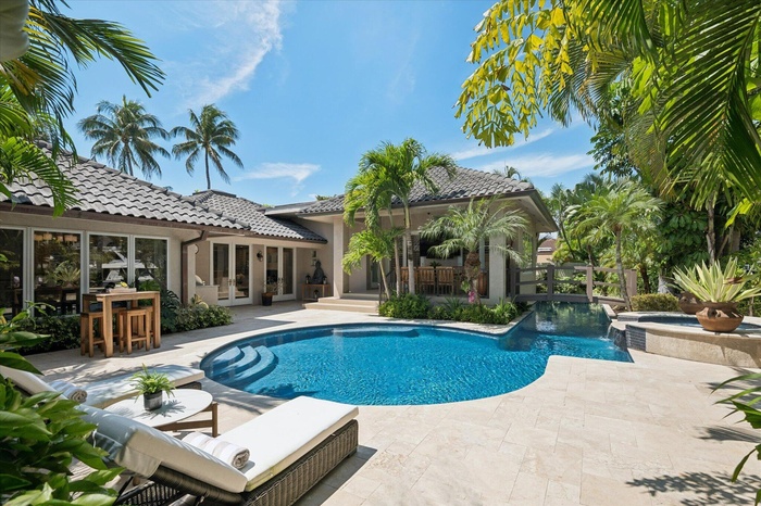 This backyard oasis includes a summer kitchen, outdoor dining area, heated/chilled saltwater pool with lap lane, waterfall spa, and private dock entra