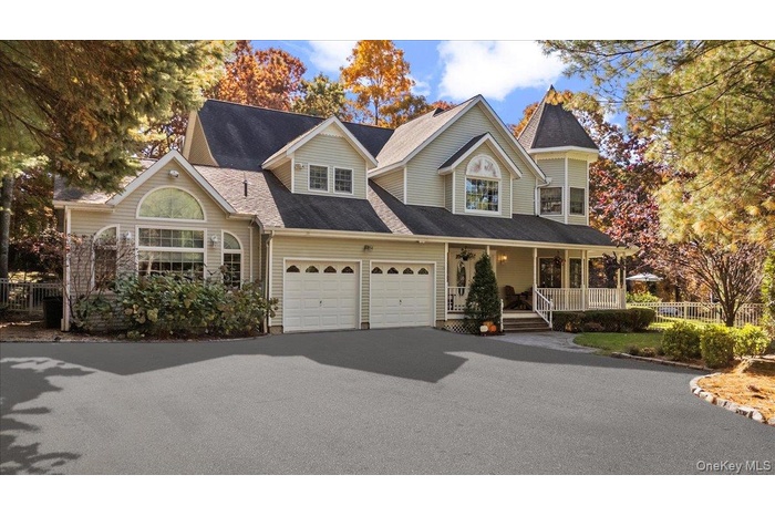View of front of house featuring a porch, driveway, a garage, and a shingled roof