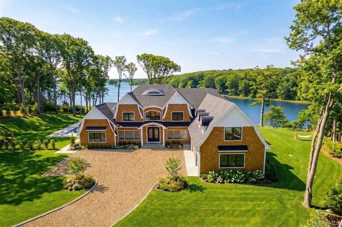 View of front facade with a front lawn and a water view
