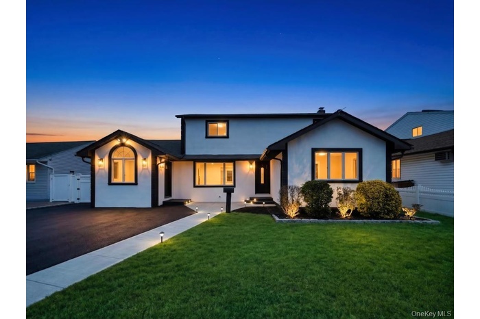 Modern-style exterior featuring a white facade with dark trim, an arched window, and multiple outdoor sconces