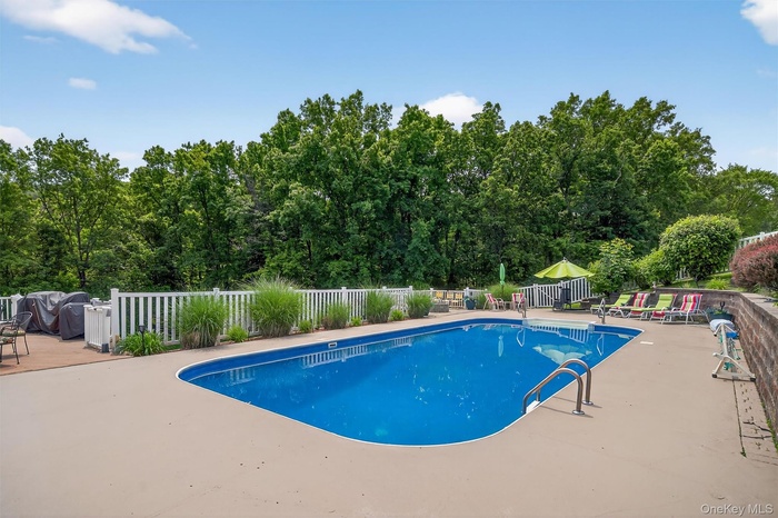 View of swimming pool featuring a patio, firepit, private cabana with additional amenities, changing area and dining space.