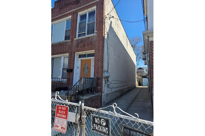 View of front of house with a gate, brick siding, and a fenced front yard
