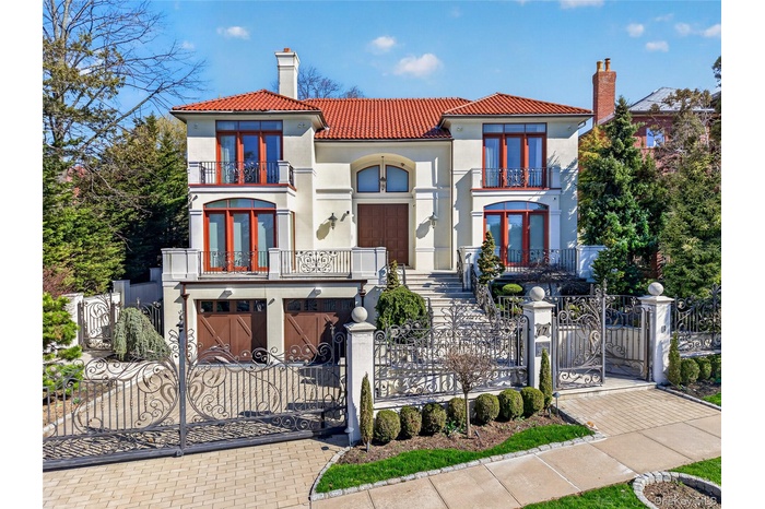 Mediterranean / spanish house with a chimney, a gate, a fenced front yard, a balcony, and stucco siding