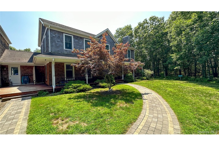 View of front of house featuring a chimney and a front lawn