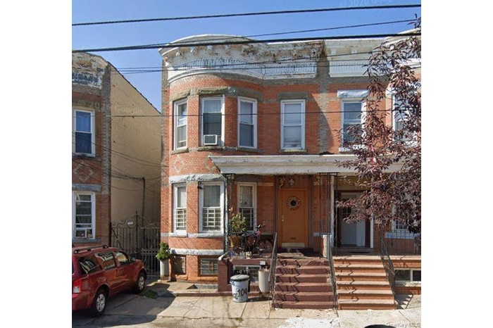 The property features a brick exterior with a distinctive curved bay window design