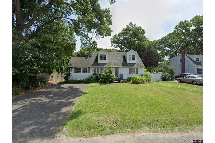 Cape cod home with fence, a front yard, and aphalt driveway