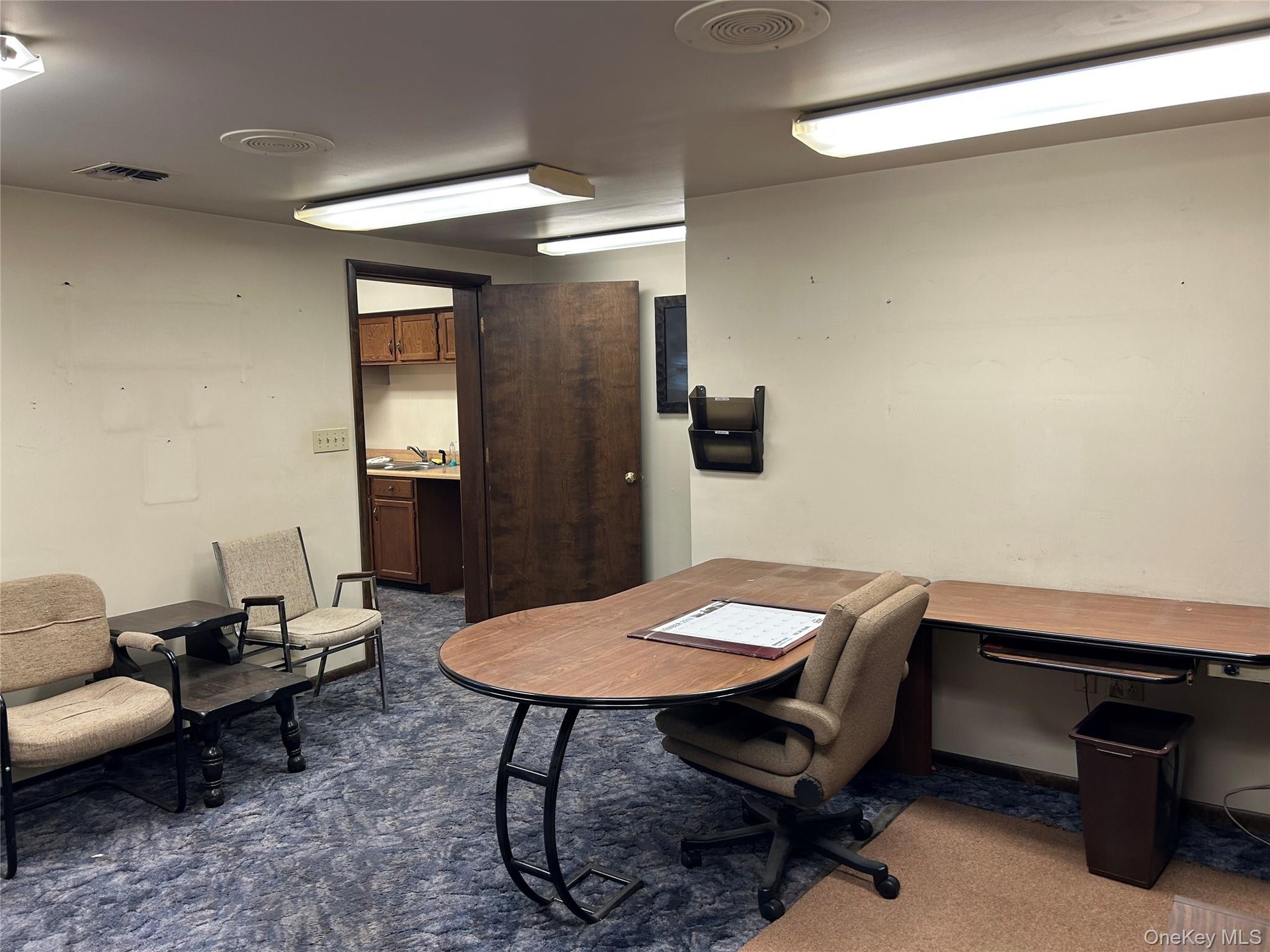 Home office featuring built in desk and dark colored carpet