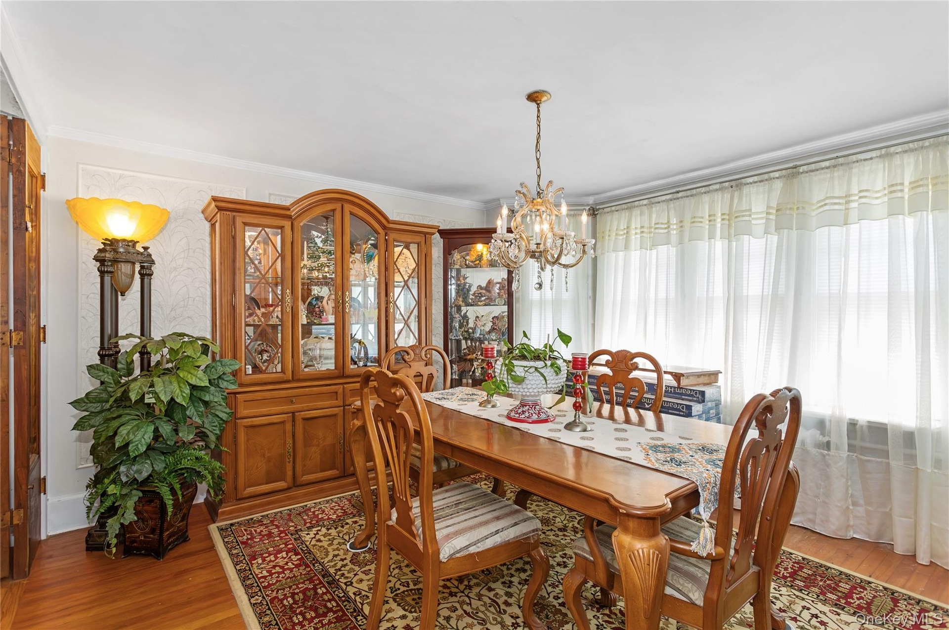 Dining room featuring a chandelier, light wood-style floors, and crown molding