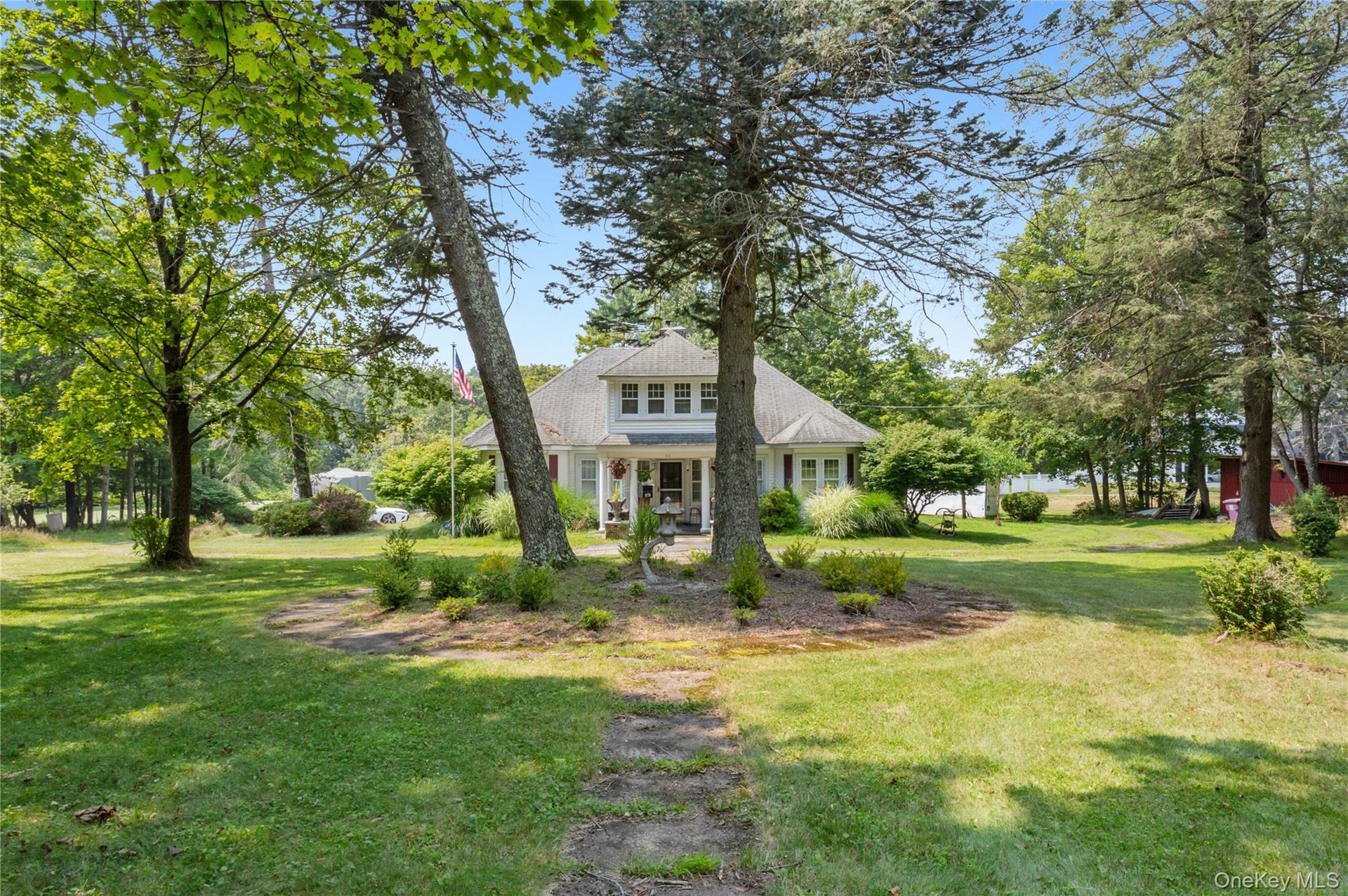 View of front of home with a front lawn and a shingled roof
