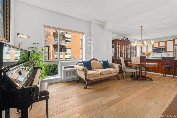 Open concept living dining areas with 2 tall floor to ceiling windows