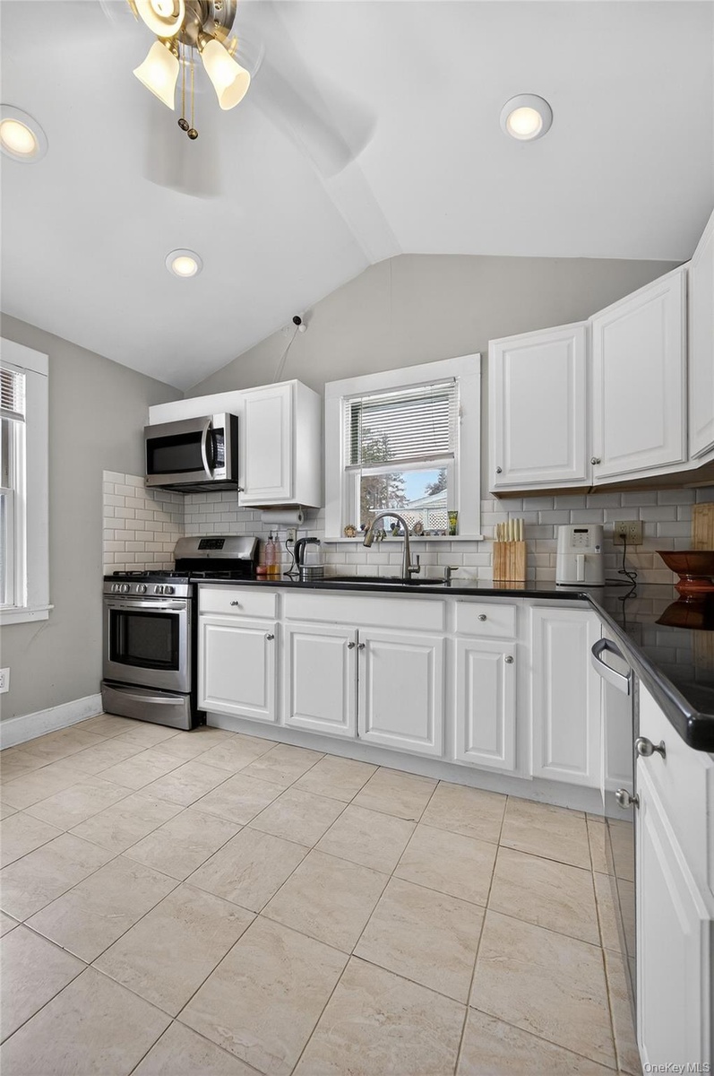 Bright sunny Kitchen with ceiling fan, recessed lighting  and plenty of space in the cabinetry.