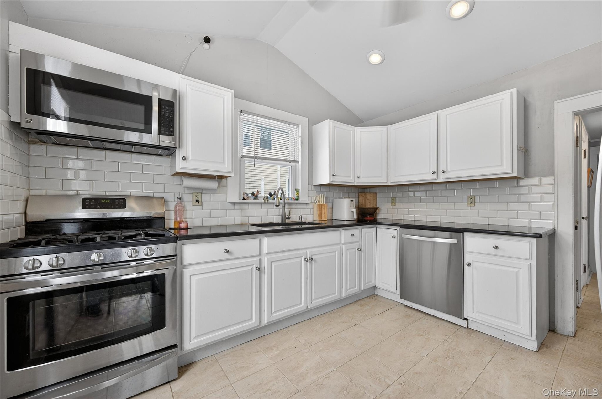 Spotless Kitchen with nice white cabinetry, stainless steel applicances and access to the side yard.