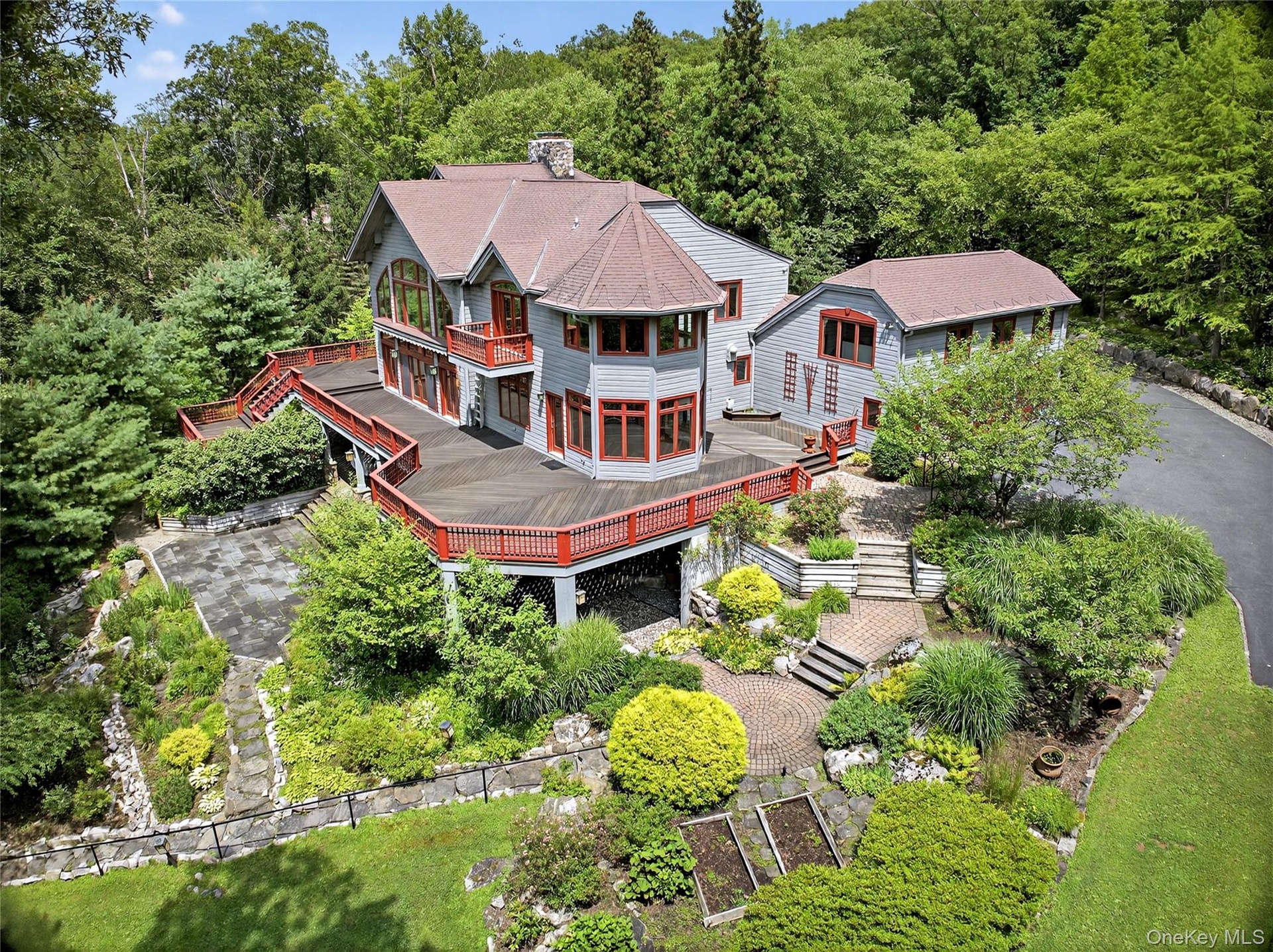 Aerial view of property and surrounding area with a forest