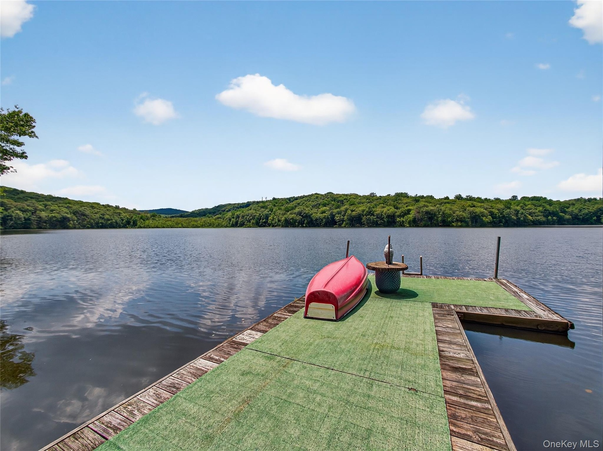 Dock area with a water view and a wooded view