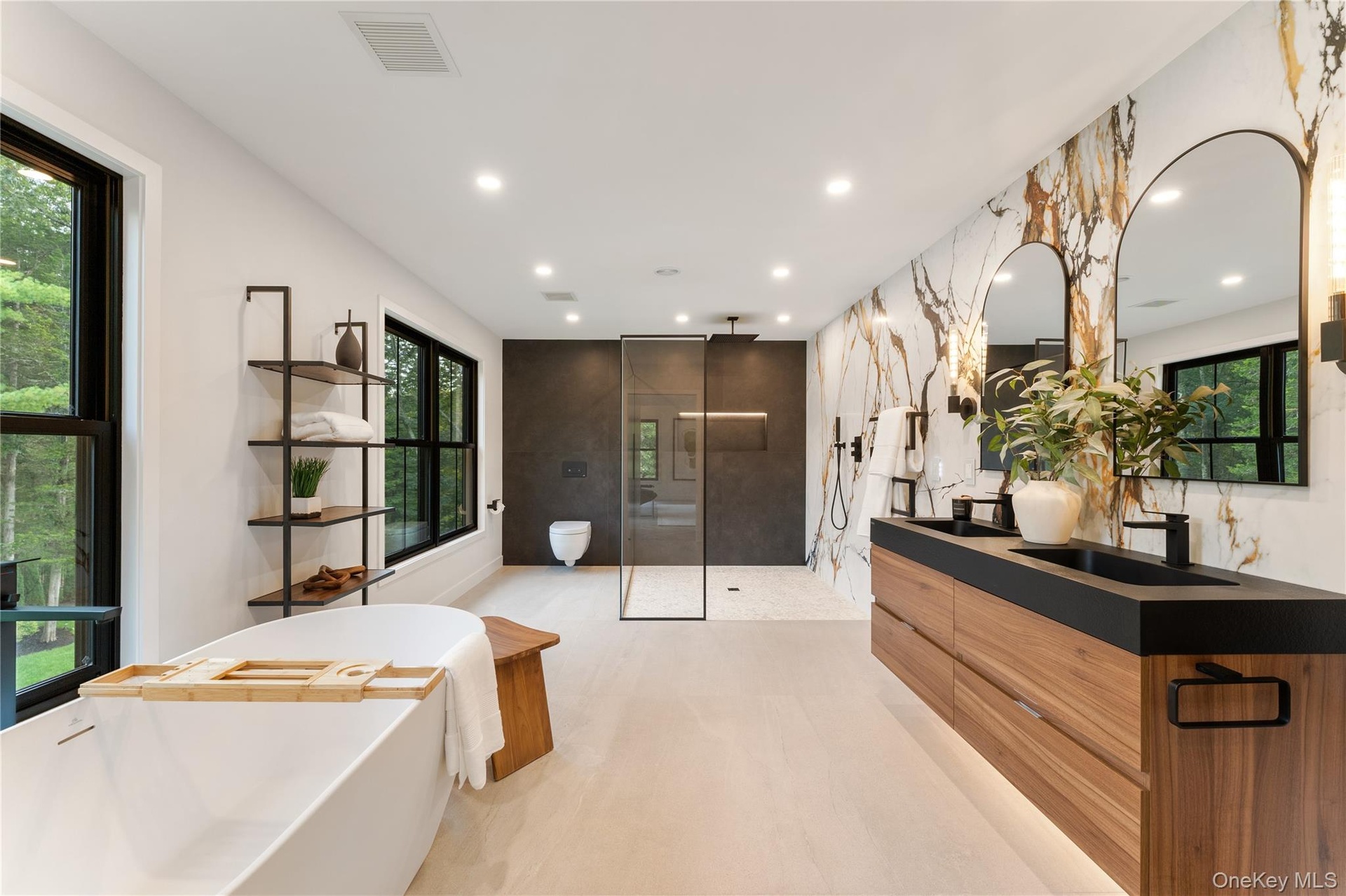 Full bath featuring a walk in shower, double vanity, a freestanding bath, and recessed lighting