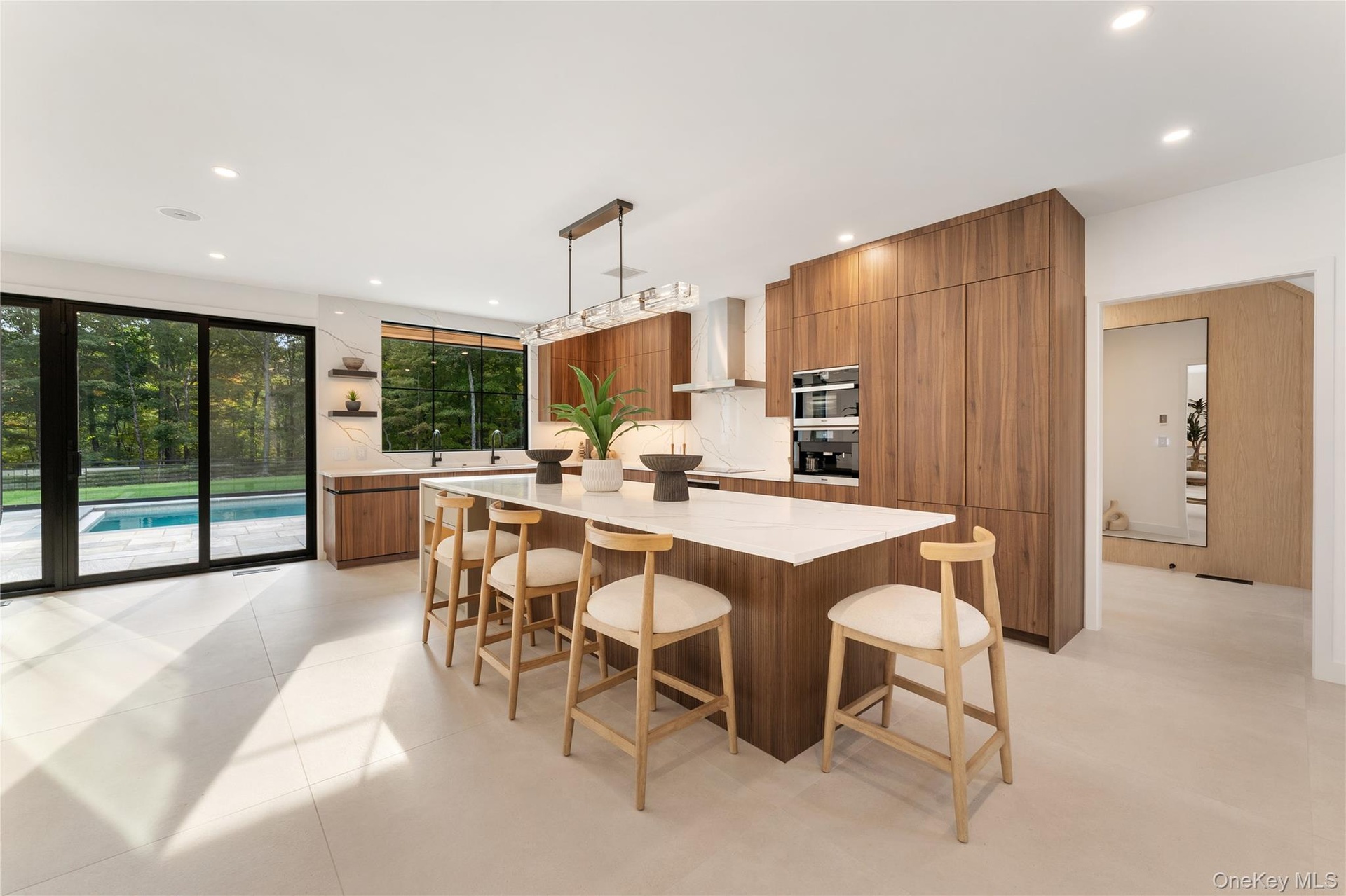 Kitchen featuring modern cabinets, brown cabinets, a breakfast bar area, decorative light fixtures, and a center island