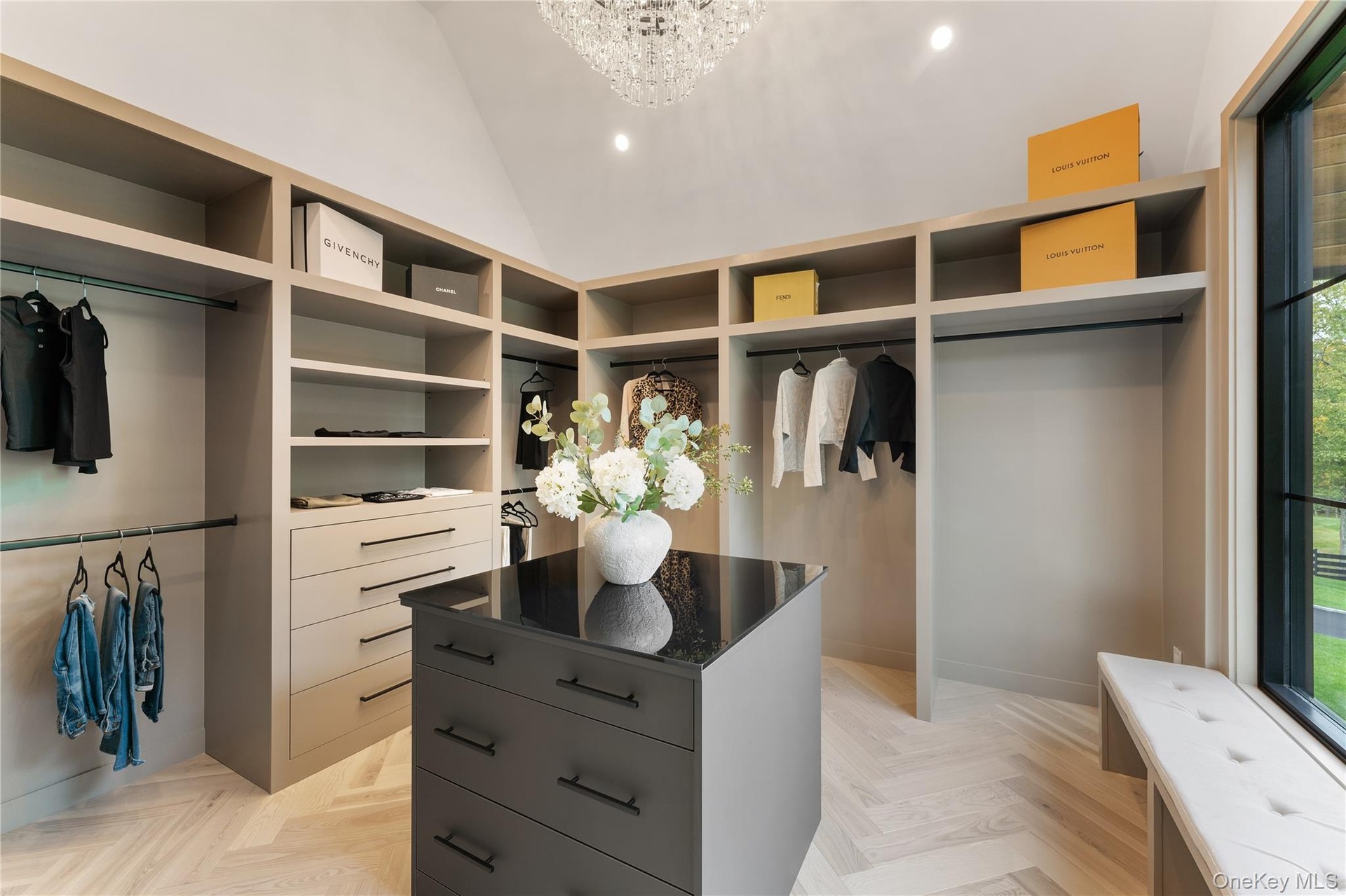 Walk in closet with a chandelier and lofted ceiling