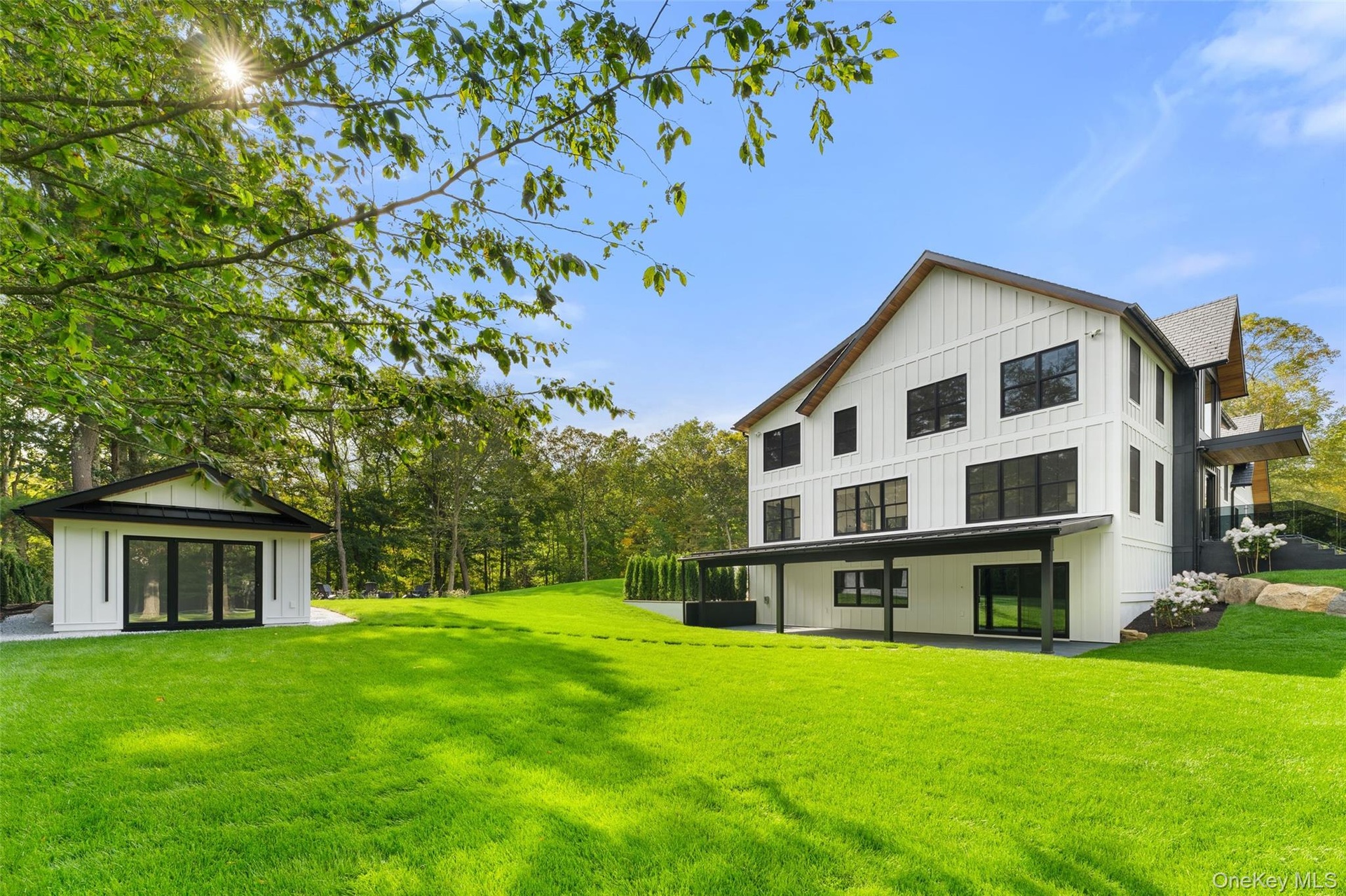 Back of property featuring board and batten siding and a yard