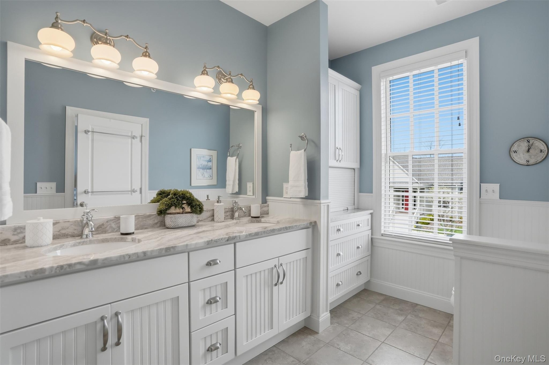 Custom built-in storage along with a convenient garage-style compartment in this private cammode area