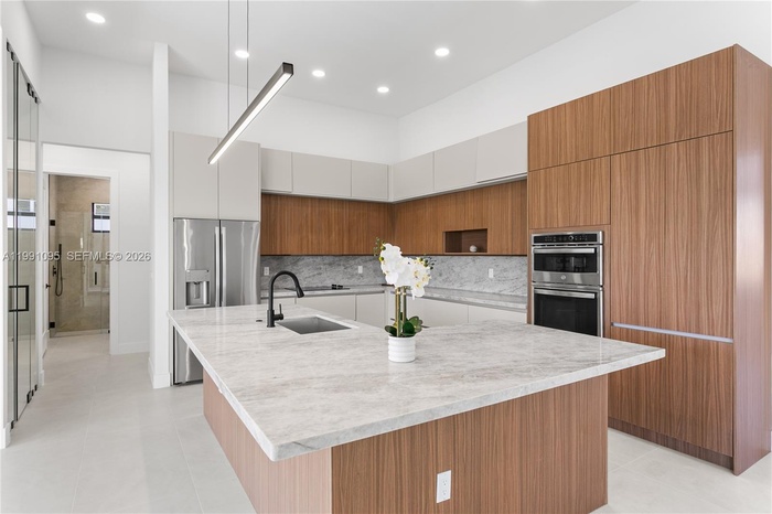 The CHEF'S KITCHEN offers OVERSIZED L-SHAPED ISLAND w/ MARBLE COUNTERTOP & extra entertainment space! Custom cabinetry, MARBLE TAJ MAHAL COUNTERTOPS w