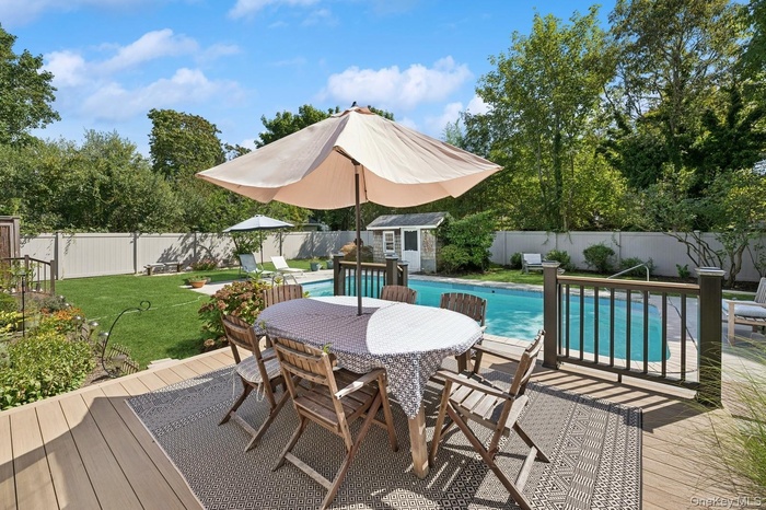 Dining on the new wooden deck with large fenced-in yard.