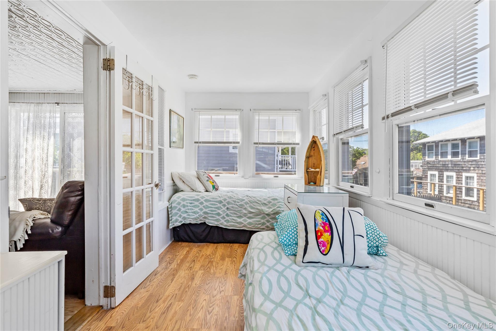 Bright interior space featuring wood-finish flooring and white vertical paneling