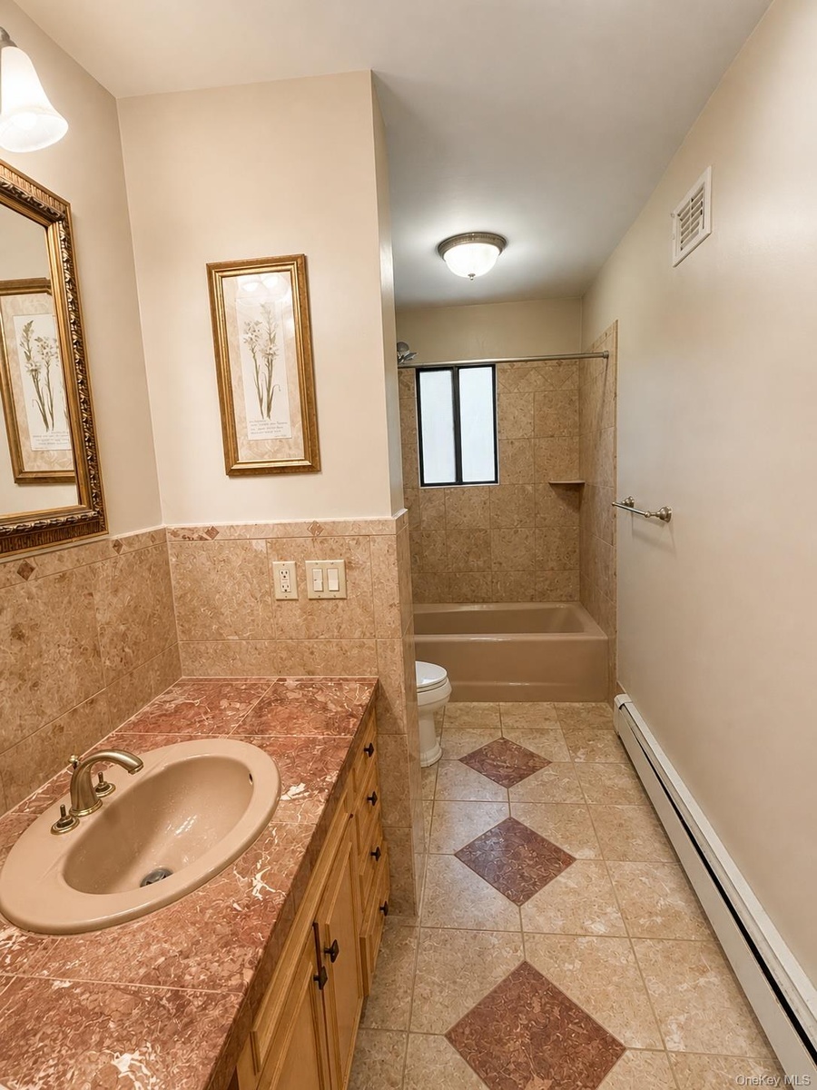 Bathroom vanity with a built-in sink, gold-toned faucet, and cabinetry