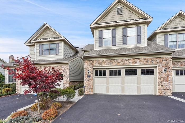 Craftsman inspired home with driveway, stone siding, and a garage