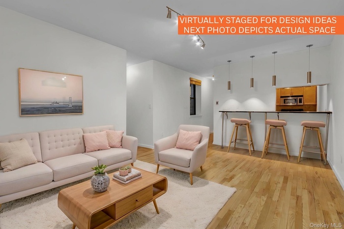 Open concept living area featuring wood-finish flooring and a breakfast bar