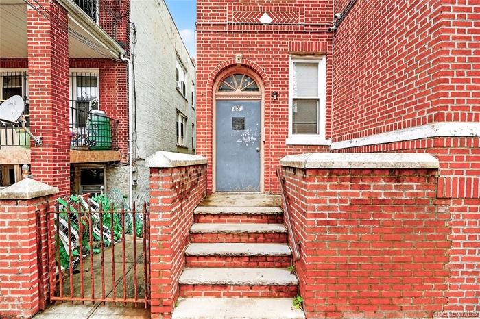 View of exterior entry featuring brick siding