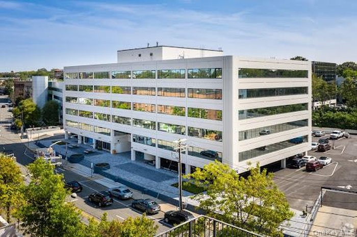 View of apartment building / complex featuring uncovered parking
