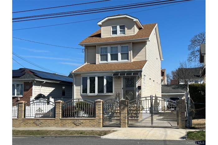 Two-story residence featuring light-colored siding and a dormer window