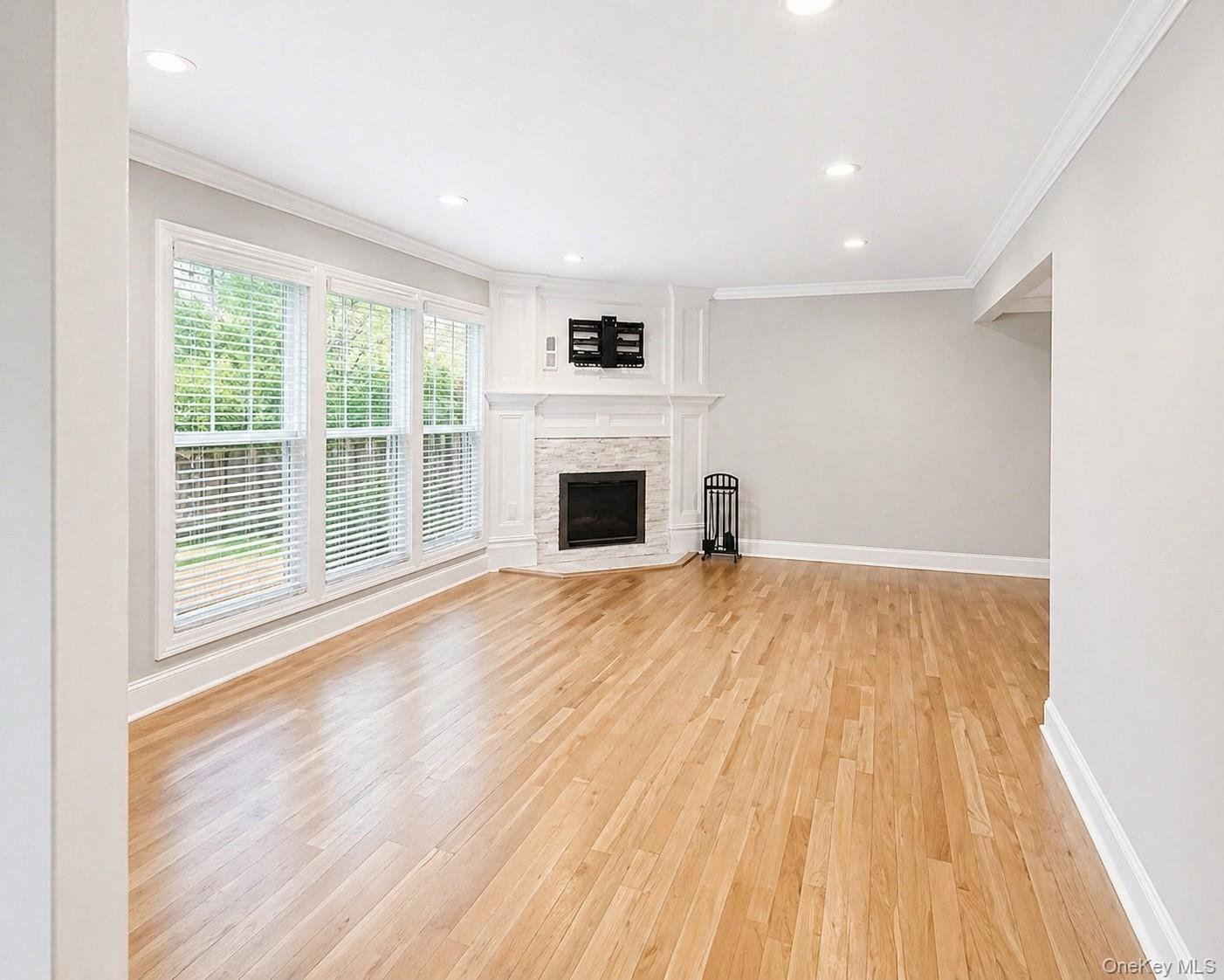 Spacious Living Room area featuring polished wood flooring, recessed lighting and a Fireplace