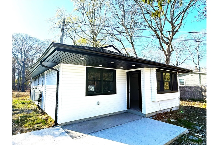 White vinyl siding exterior with dark trim and black window frames