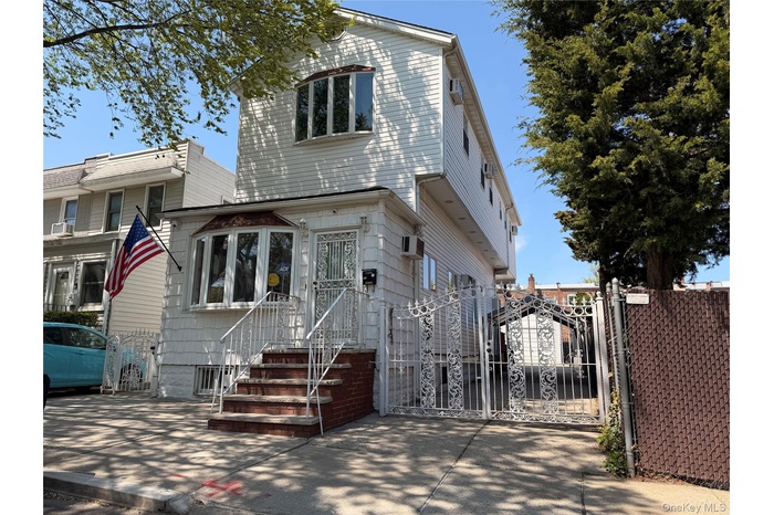 Two-story residence featuring white vinyl siding and a brick-faced foundation