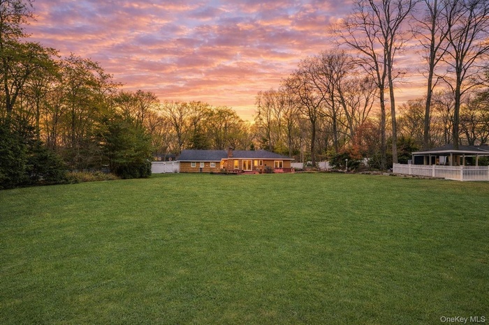 View of grassy yard with view of scattered trees