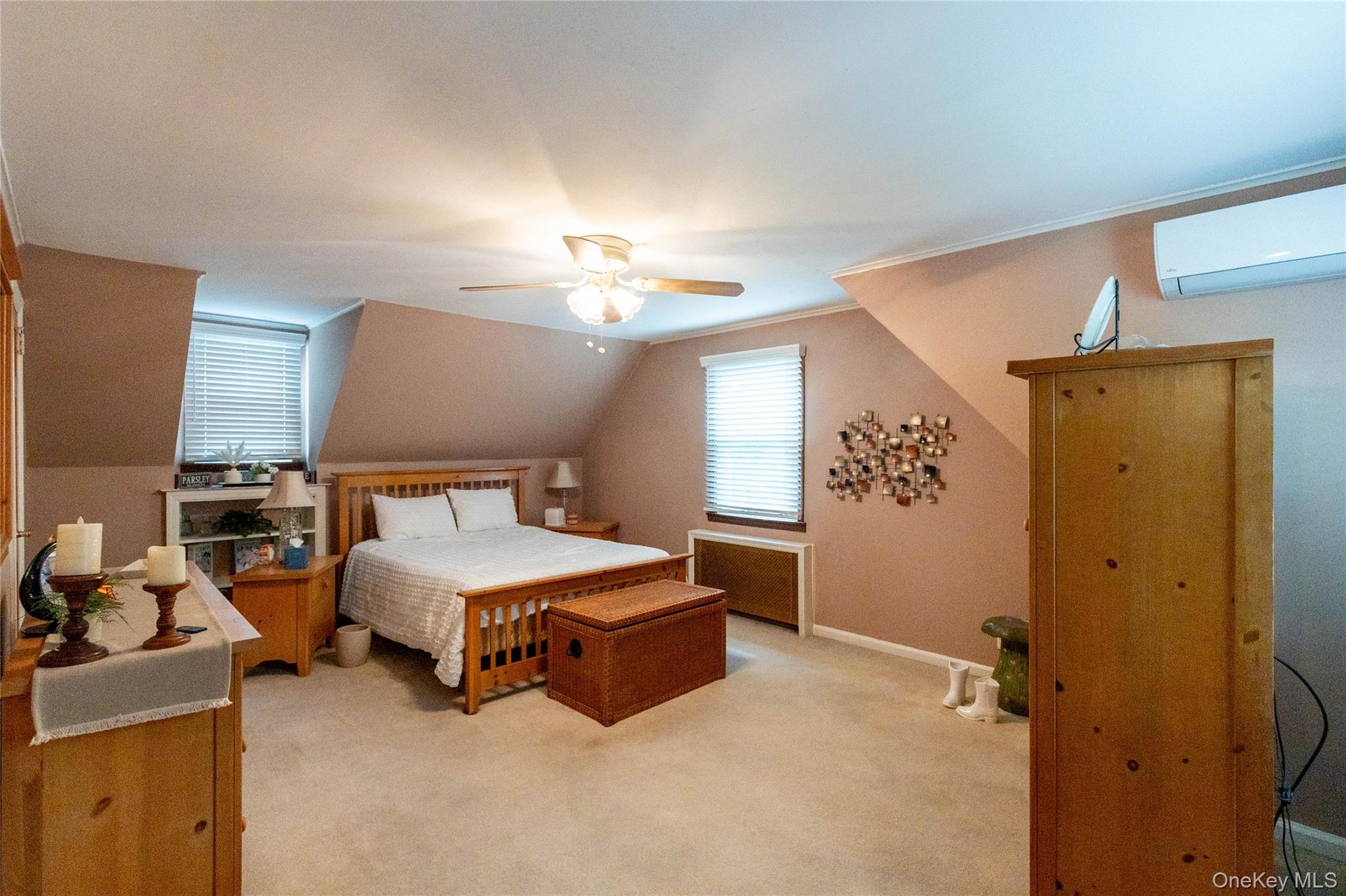 Carpeted room with sloped ceilings and a ceiling fan light fixture