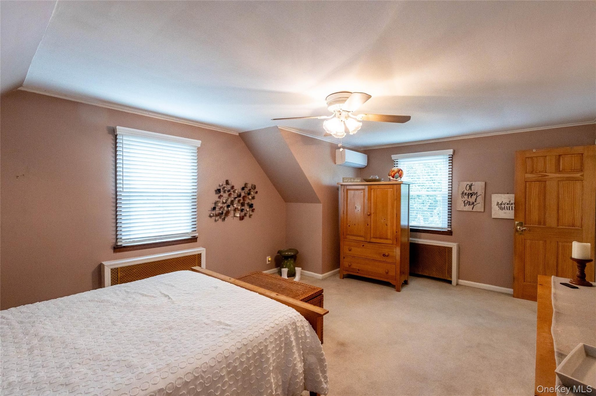 Carpeted room featuring sloped ceilings and a ceiling fan with integrated lighting