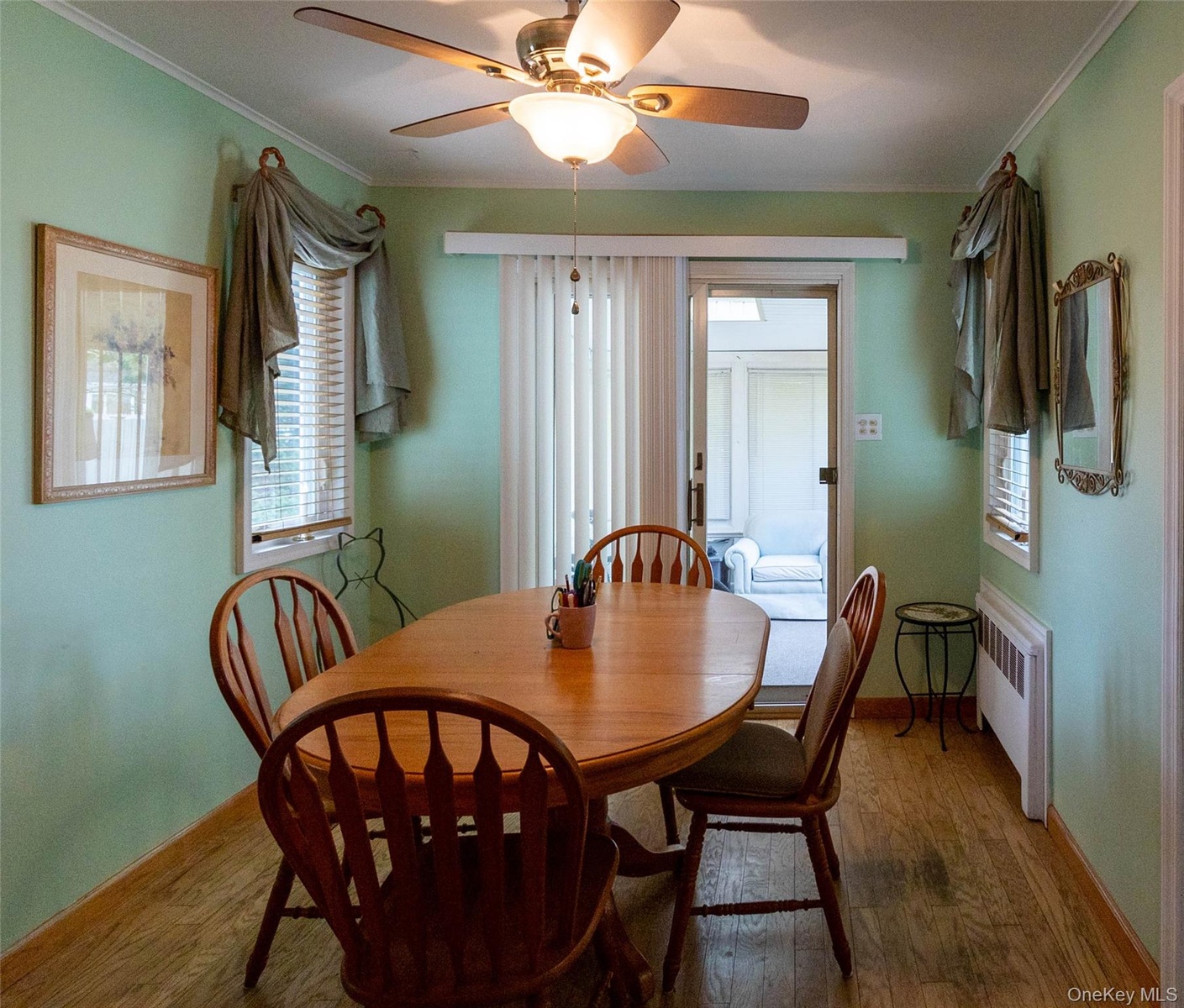 Dining area featuring wood-finish flooring and a ceiling fan with integrated lighting