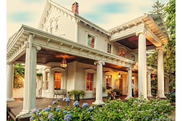 Victorian-style residence featuring a prominent full-width porch with fluted columns and detailed trim work