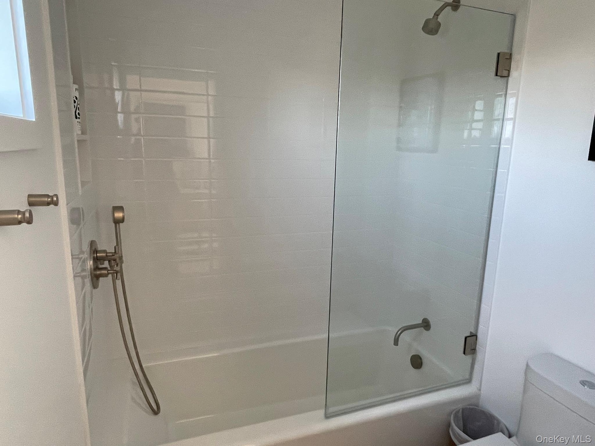 Full bathroom featuring toilet and combined bath / shower with glass door