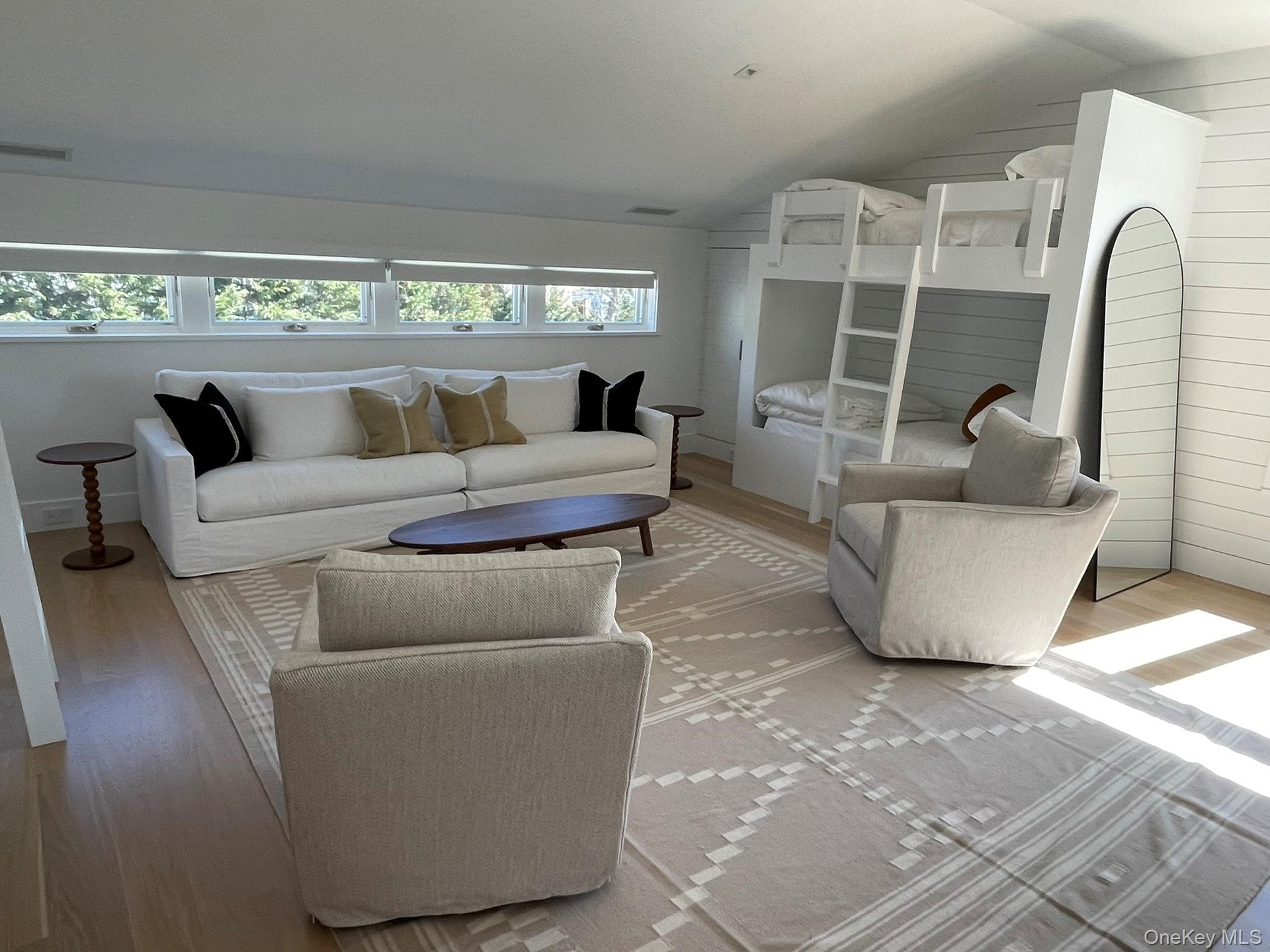 Living room with light wood-style flooring, visible vents, and vaulted ceiling