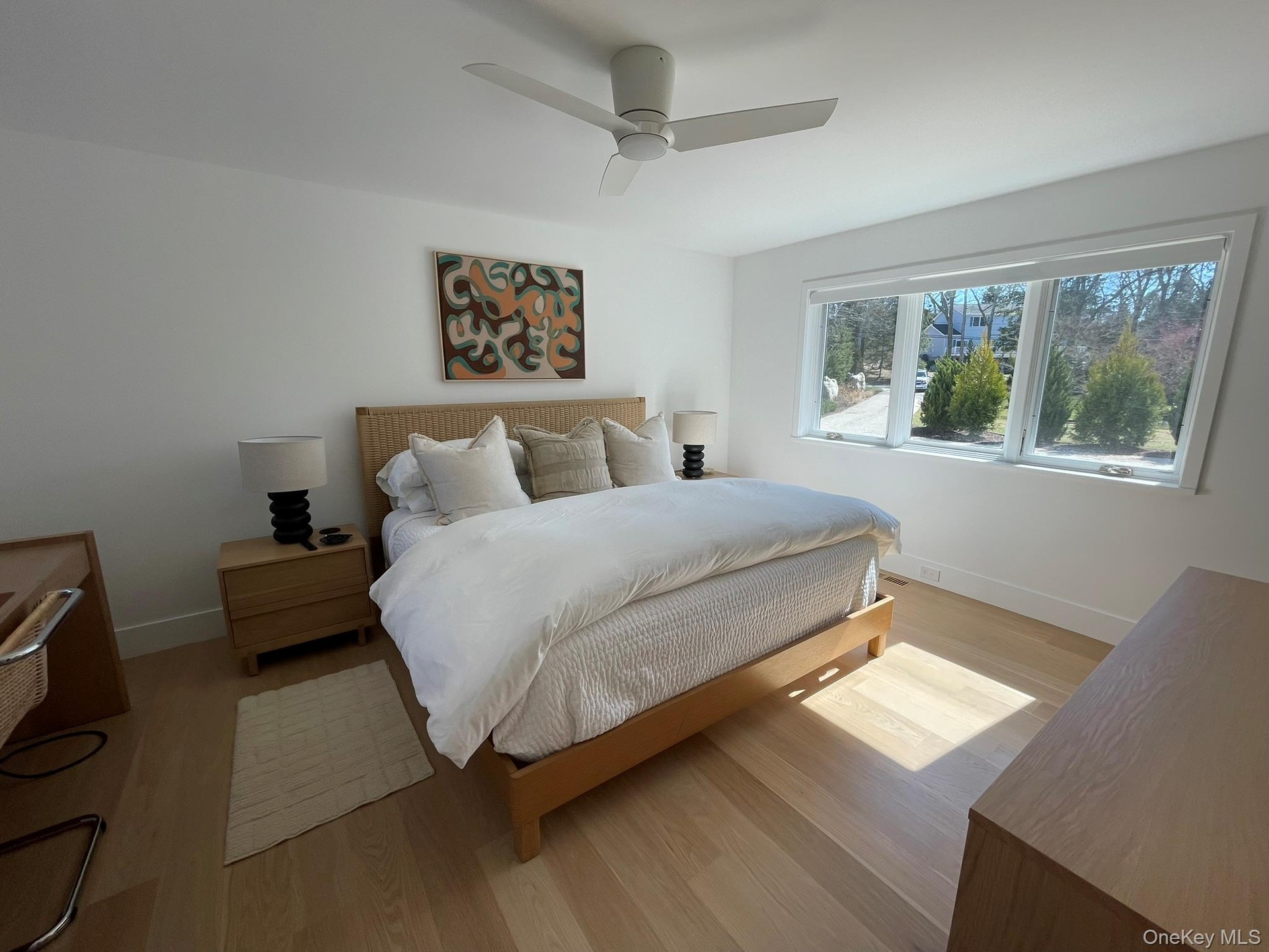 Bedroom with light wood-style flooring, baseboards, and a ceiling fan