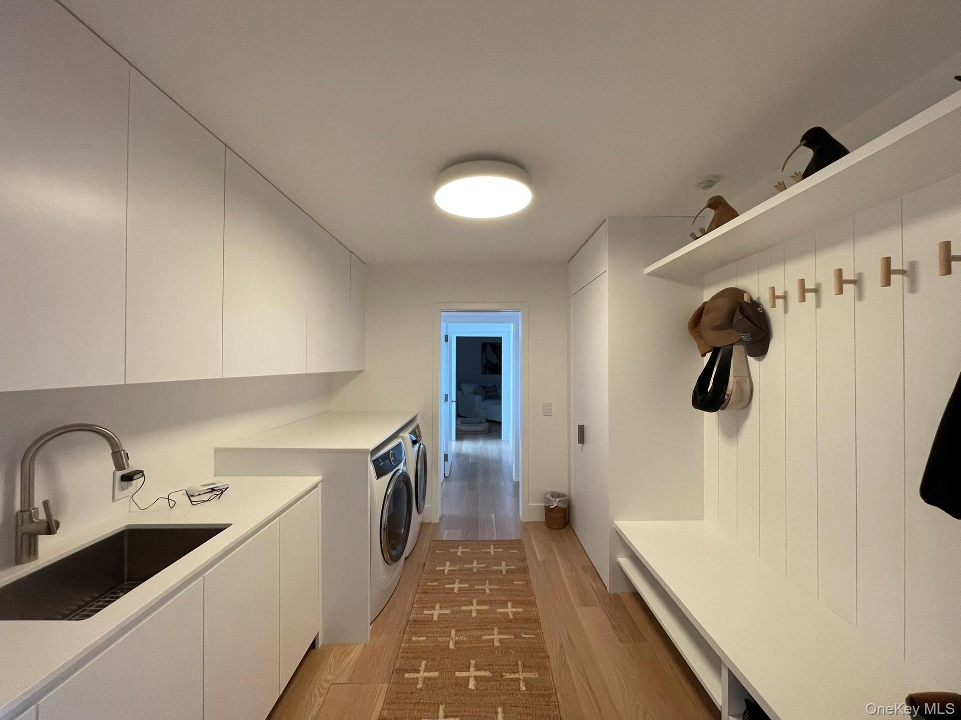 Washroom with a sink, light wood-style flooring, cabinet space, and washing machine and dryer