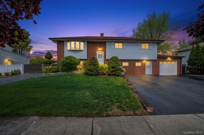Hi-Ranch home featuring brick and siding exterior, a bay window, and an attached single-car garage