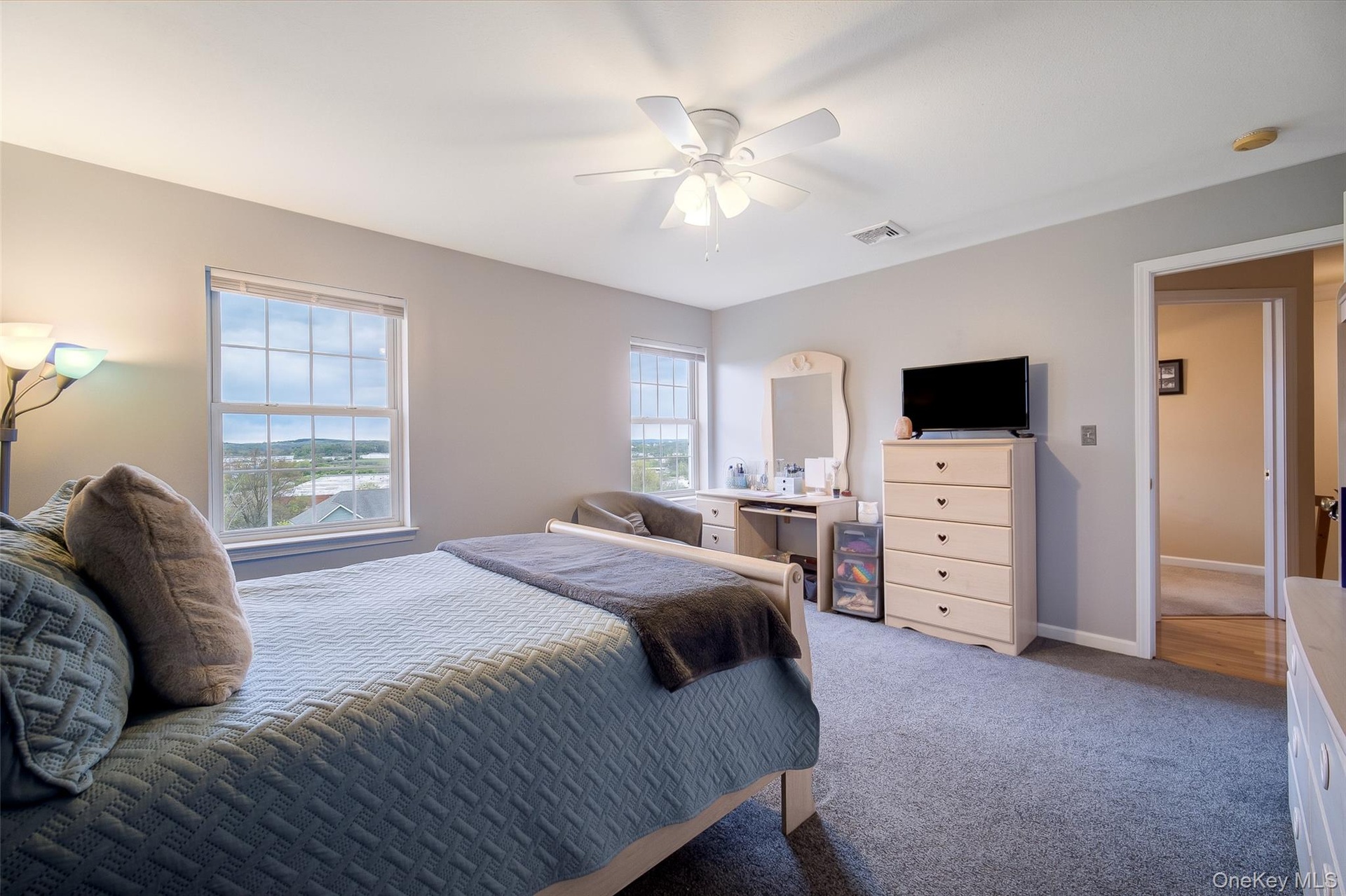 Carpeted with ceiling fan and views.