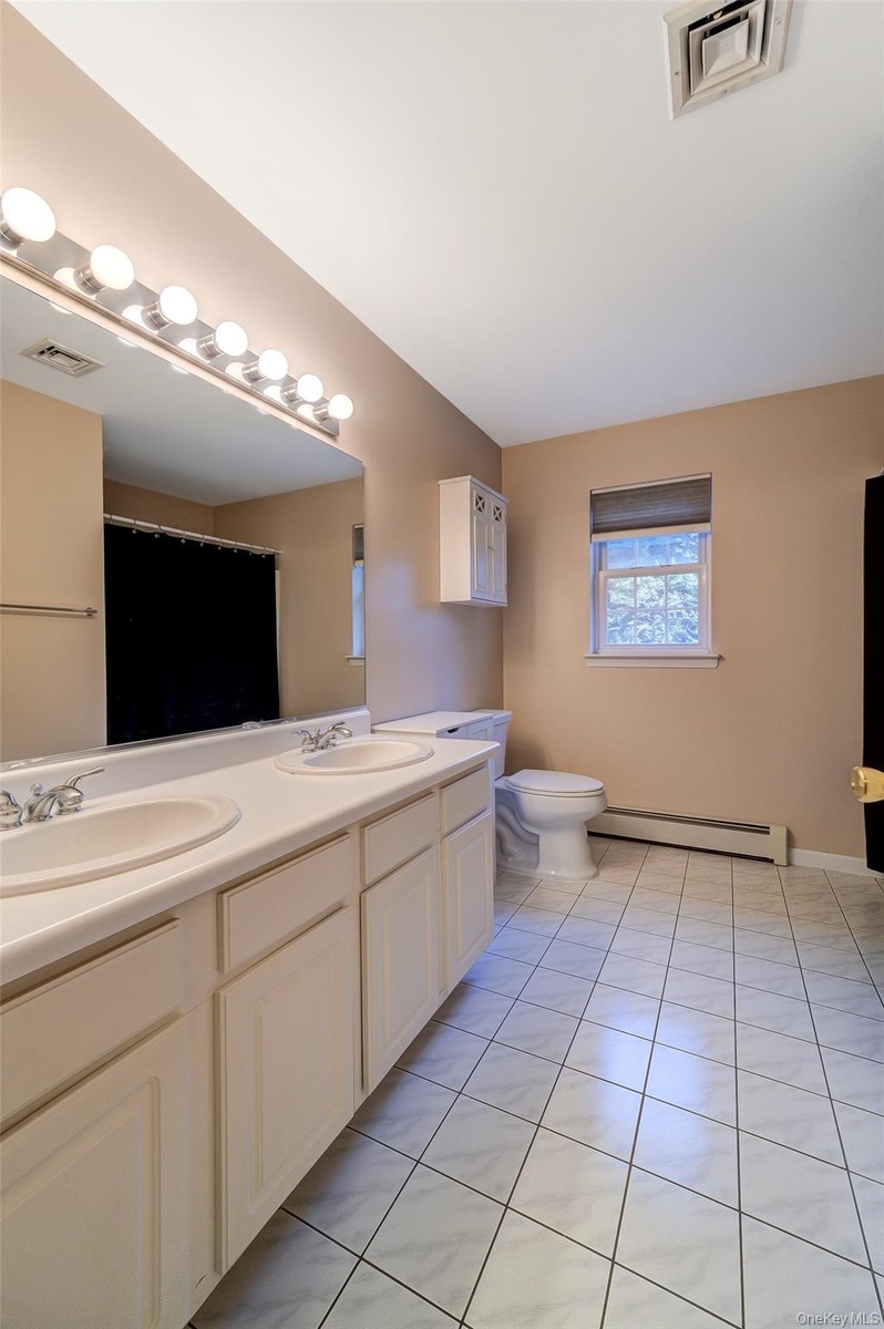 2nd floor main bath with tiled floor, custom lighting and double vanity