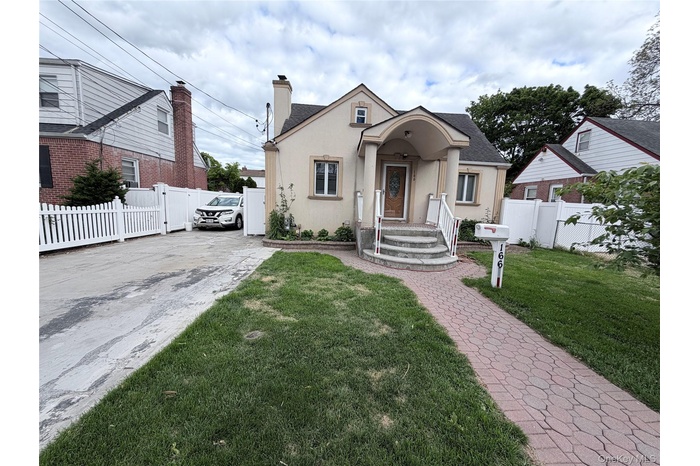 Charming stucco exterior with a covered entryway and arched portico