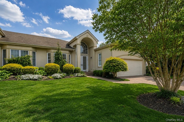 Stucco exterior with a peaked entryway featuring an arched transom window