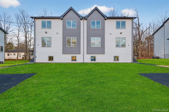 Rear view of house featuring a lawn